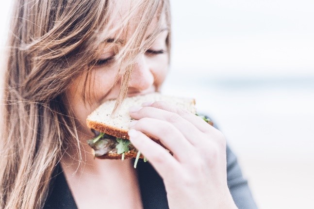 Woman eating bread which can affect insulin resistance